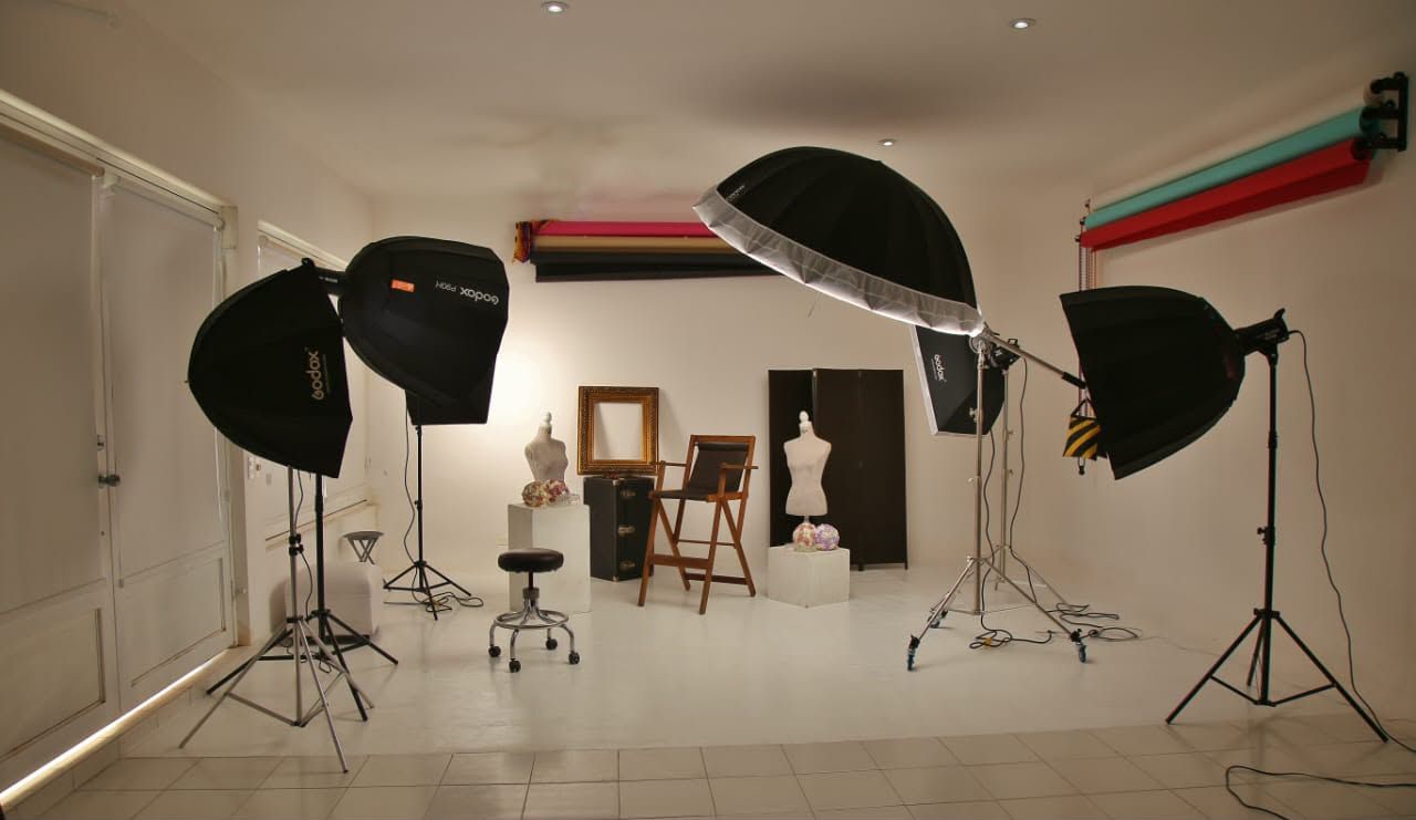 Estudio cubierto con tres luces montadas y piso claro