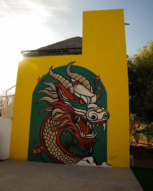 Mural de un dragón sobre pared amarilla